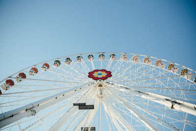 Low angle view of ferris wheel against clear blue sky