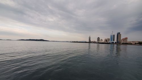 Scenic view of sea by buildings against sky