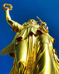 Low angle view of statue against blue sky