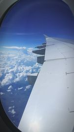 Airplane flying over blue sky seen through window