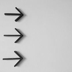 Close-up of arrow sign on wall