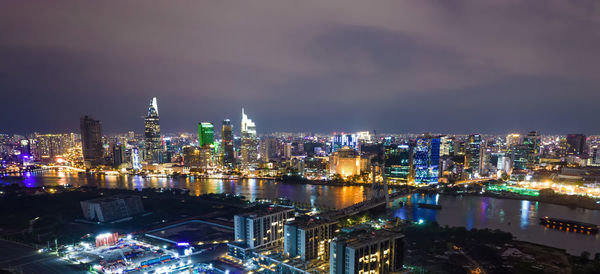 High angle view of illuminated buildings against sky at night