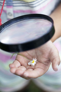 Girl looking at flower trough magnifying glass