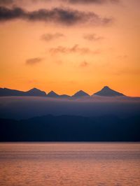 Scenic view of silhouette mountains against romantic sky at sunset