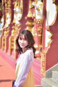 Portrait of smiling young woman standing in city