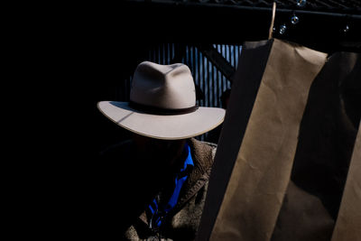 Man in the shadows wearing a hat 