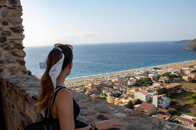 Rear view of woman looking at sea against sky