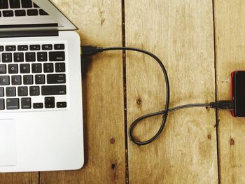 Close-up of laptop charging on table