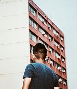 Rear view of man looking at modern building in city