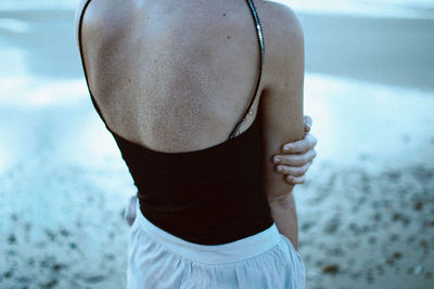 Rear view of woman standing on beach