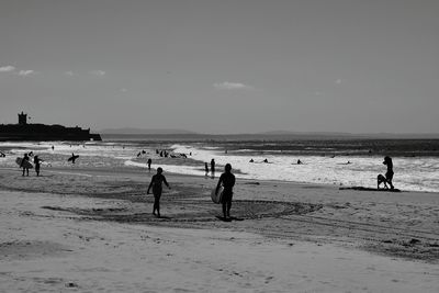 People on beach against sky