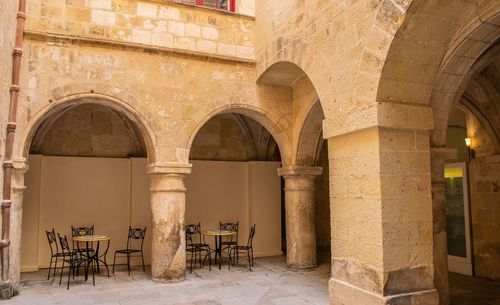 Empty chairs and table in old building