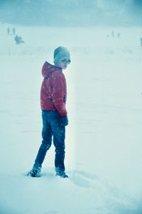 Full length of girl standing on snow covered field