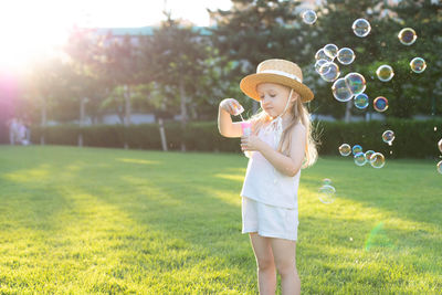 Cute girl blowing bubbles at park