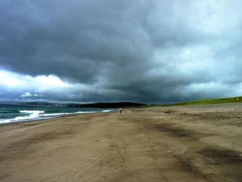 Scenic view of beach against cloudy sky during storm