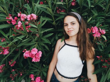 Portrait of smiling young woman standing with flowers