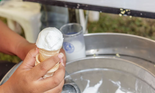 Midsection of woman holding ice cream in glass