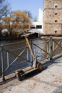 Two drowned electric rent scooters in the mud stand on the city's embankment. vandals throw scooters