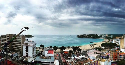 Panoramic view of city by sea against sky