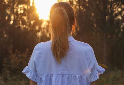 Rear view of woman standing in forest