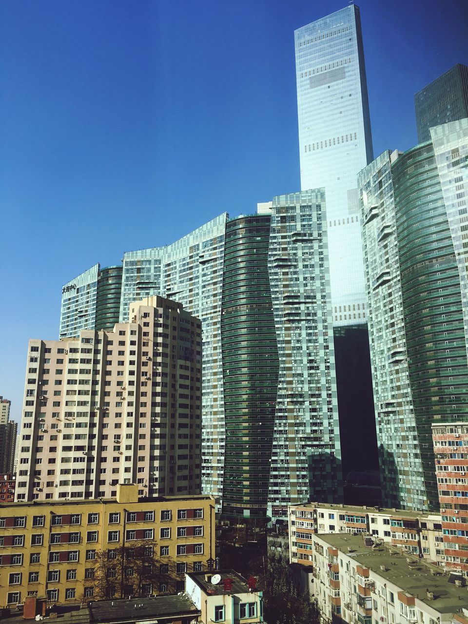 city, skyscraper, building exterior, architecture, built structure, clear sky, day, no people, growth, sunlight, outdoors, modern, development, low angle view, cityscape, sky