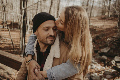 Young couple kissing in park during winter