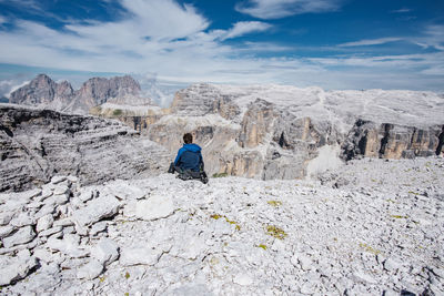 Rear view of people on rock against sky