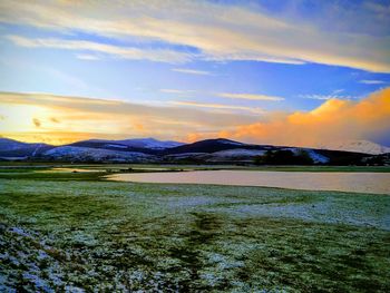 Scenic view of field against sky during sunset