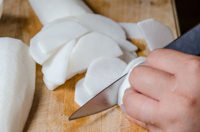 Cropped hand cutting vegetable