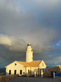 Lighthouse by sea against sky