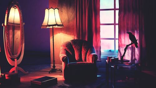 Illuminated lamp on table at home