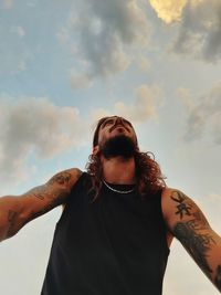 Portrait of young man standing against sky