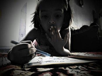 Portrait of girl sitting on table at home