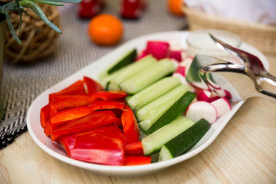 Cucumber, radish and bell pepper on a plate. vegetable appetizers on the table.