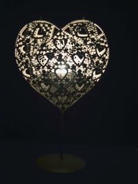 Close-up of illuminated light bulb over black background