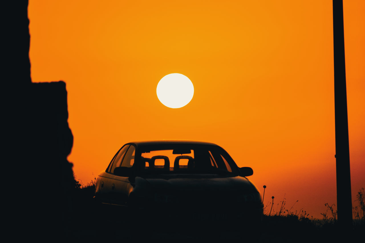 SILHOUETTE CAR ON ROAD AGAINST ORANGE SKY