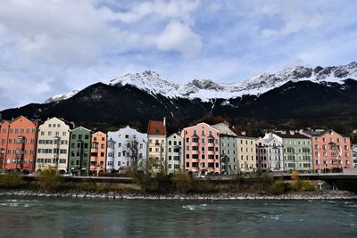 Buildings by mountains against sky