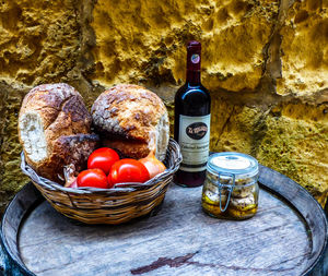 Fruits in basket on table against wall