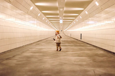 Full length of man walking in illuminated tunnel