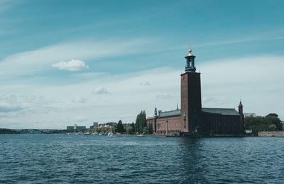 Buildings by sea against sky in city