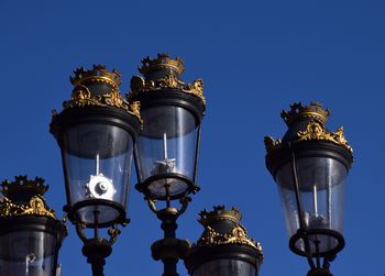 Low angle view of illuminated street light against clear blue sky