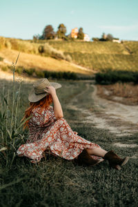 Portrait of young woman sitting on field