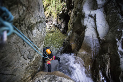 High angle view of man rappelling down waterfall in cypress canyon.