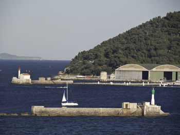 Sailboats in sea against clear sky