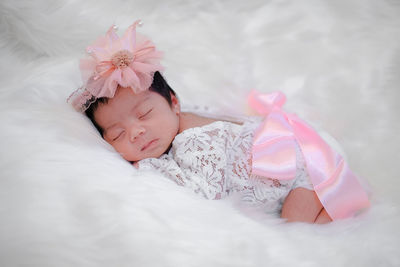 Cute newborn baby sleeps on white fluffy coverlets