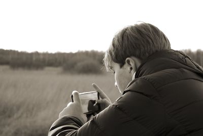 Side view of a boy using mobile phone