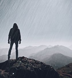 Man standing on mountain against sky