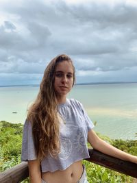 Portrait of beautiful woman against sea against sky