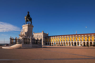 Illuminated buildings against clear blue sky