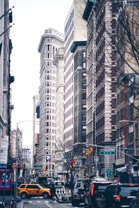 Traffic on road amidst buildings in city